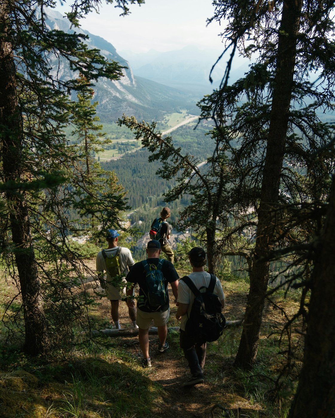 Hikers following an alpine trail beneath dramatic mountain peaks