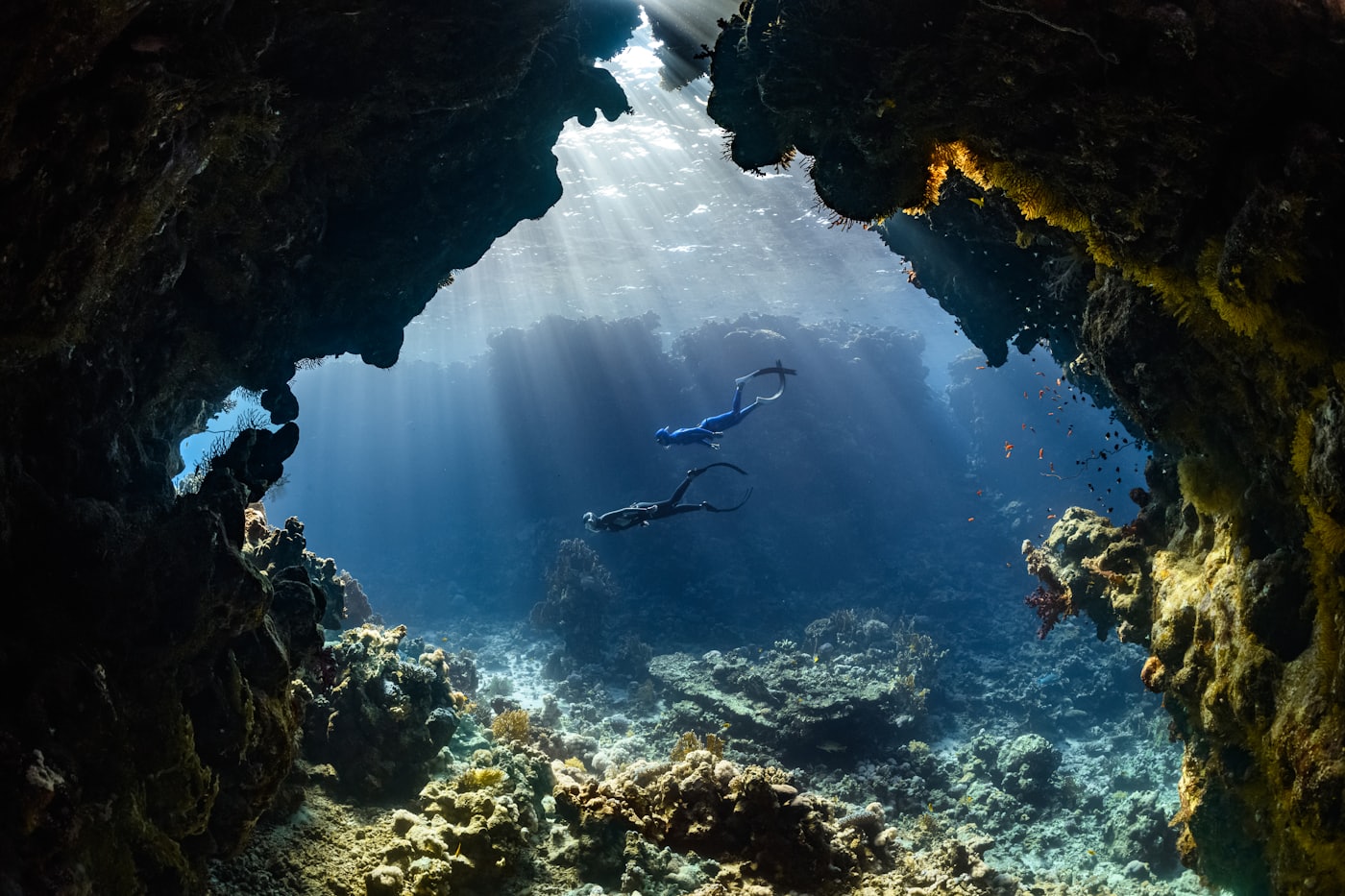 An explorer moving through a dramatic cave environment